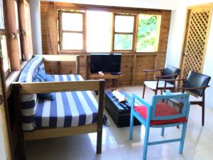 una camera con un letto, due sedie e una TV di Hostal Casaluna San Andres a San Andrés