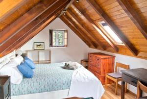 ein Schlafzimmer mit einem Bett und einer Holzdecke in der Unterkunft Casa da Manta - Palheiro in Fajã da Ovelha