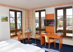 a hotel room with a desk and a bed at Hotel Spreewaldeck in Lübbenau