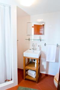 ein Badezimmer mit einem weißen Waschbecken und einer Dusche in der Unterkunft Casa da Manta - Palheiro in Fajã da Ovelha