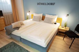 ein großes weißes Bett in einem kleinen Zimmer in der Unterkunft KEMPE Komfort Hotel in Düsseldorf