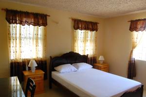 Un pat sau paturi într-o cameră la Manderley Villas