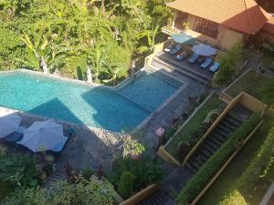 an overhead view of a swimming pool with chairs and umbrellas at Sri Aksata Ubud Resort by Adyatma Hospitality in Ubud
