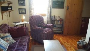 a living room with a couch and a chair at Millwood Cottage in Lisbellaw