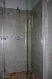 リロングウェにあるMalabi Exclusive Lodgesのバスルーム(ガラスドア付きのシャワー付)