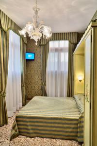 1 dormitorio con cama y lámpara de araña en Hotel Al Malcanton, en Venecia