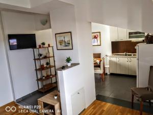 a small kitchen and living room with a table at Apartman Kiss in Osijek