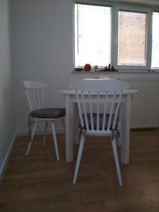 una mesa blanca y 2 sillas en una habitación en Apartament w Dolinie Popradu, en Piwniczna-Zdrój
