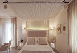 a bedroom with a large bed with a white canopy at Le Nicchie Guest House in Lucera