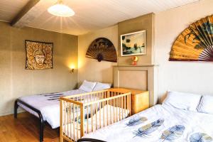 a bedroom with two twin beds and a crib at Relax @ Maison Sax in Oppagne
