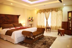 a large bedroom with a large bed and a couch at Meraki Hotel in Baños