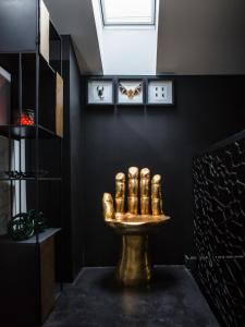 baño con lavabo de oro en una pared negra en Boutique Hotel K7, en Bad Nauheim