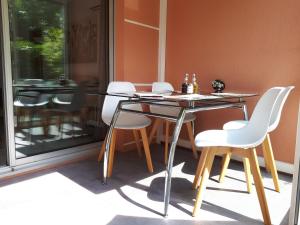 カーニュ・シュル・メールにあるZen Attitude Apartmentのガラスのテーブルと椅子が備わるパティオ