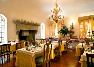 a dining room with tables and chairs with a chandelier at Tenuta La Bandita in Sassetta
