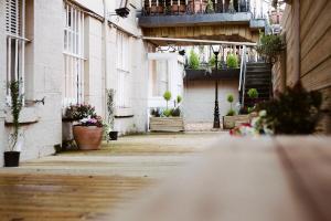 an empty street with potted plants and a balcony at Argyll Apartments in Glasgow