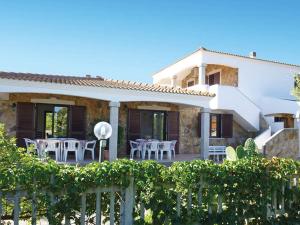 een huis met een patio met tafels en stoelen bij LE MAREE I LENTISCHI in San Teodoro