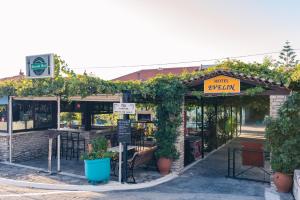 Evelin hotel في بيثاغوريو: مطعم فيه بركولا عليه نباتات