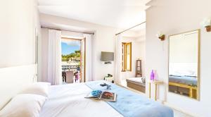 a white bedroom with a bed and a large window at Villa Rossa in Parga