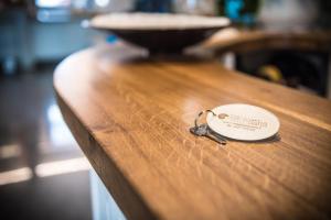 a key on top of a wooden counter with a bowl at Hotel Jesolo Sand in Lido di Jesolo