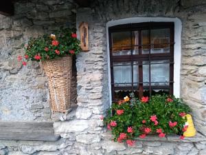 een raam met twee manden bloemen en een vensterbank bij Agriturismo Meizoun Blancho in Fenestrelle