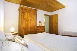 1 dormitorio con 1 cama y armario de madera en Apartmány Pod Chopkom en Pavčina Lehota