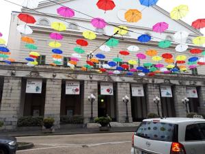 un bâtiment avec des parasols colorés suspendus au-dessus d'une rue dans l'établissement Diamond Apartment, à Gênes