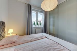 a bedroom with a large bed and a window at Apartament Stylowy in Gdynia