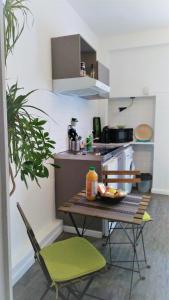 una pequeña cocina con mesa y 2 sillas en Appartement / Jungle en Sète
