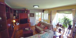 un soggiorno con un divano e una TV di Chalet Argoños ad Argoños