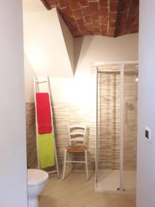 La salle de bains est pourvue de toilettes et d'une chaise. dans l'établissement Bed and Breakfast Ca D'Pandin, à Peveragno