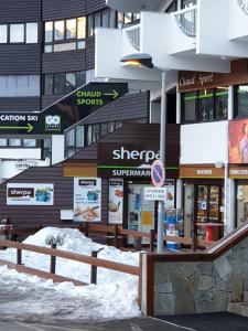 un edificio con nieve frente a una tienda en Studio Val Gardena 1, en Puy-Saint-Vincent