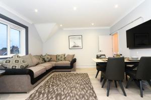 a living room with a couch and a dining room at Amazing Apartment near Bournemouth, Poole & Sandbanks - WiFi & Smart TV - Newly Renovated! Great Location! in Poole