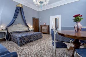 Un dormitorio con una cama y una mesa con un jarrón. en Hotel Mezzo Pozzo, en Venecia