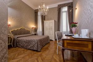 a bedroom with a bed and a table and a desk at Hotel Mezzo Pozzo in Venice