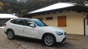 ein weißes Auto, das vor einem Gebäude parkt in der Unterkunft Il Cardo Trentino in Bedollo