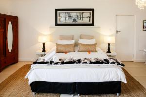 a bedroom with a large bed with two lamps at Radium Hall Guest House in Cape Town