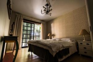 a bedroom with a bed and a window and a chandelier at Bosque Oriri in Rebouças