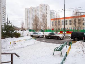 a green bench in the snow in a city at Отель Турист на Саратовской in Moscow