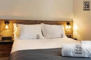 Porta 20 Boutique Guesthouse في ليريا: غرفة نوم بسرير كبير مع ملاءات ووسائد بيضاء