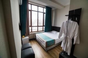 ビシュケクにあるGolden Hotelのベッドと窓が備わる小さな客室です。