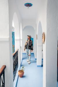 Un homme se promenant dans le couloir d'une maison dans l'établissement Dar Chefchaouen, à Chefchaouen