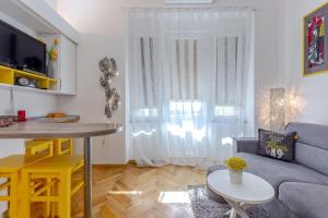 een woonkamer met een bank en een tafel bij Studio apartman Piramida in Rijeka