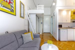een woonkamer met een bank en een hoogslaper bij Studio apartman Piramida in Rijeka