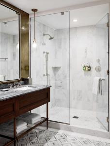 a bathroom with a glass shower and a sink at Sophy Hyde Park in Chicago