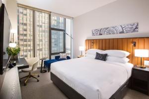a bedroom with a large white bed and a desk at Arlo Chicago in Chicago