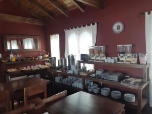 uma cozinha com paredes vermelhas e uma mesa e cadeiras em Cerro de la Cruz em Cafayate