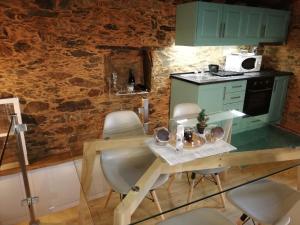 a kitchen with a table with chairs and a stove at Casinha do Talasnal in Lousã