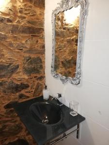 a bathroom with a black sink and a mirror at Casinha do Talasnal in Lousã +42 photos