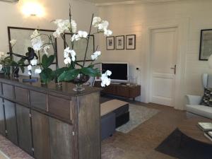 uma sala de estar com um vaso de flores brancas num armário em FdM Stay 1 em Forte dei Marmi