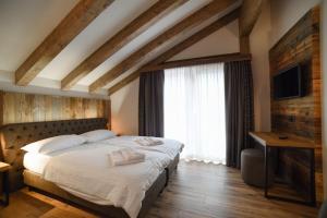 una camera con un grande letto e una televisione di Residence & Wellness 3MILA a Peio Fonti